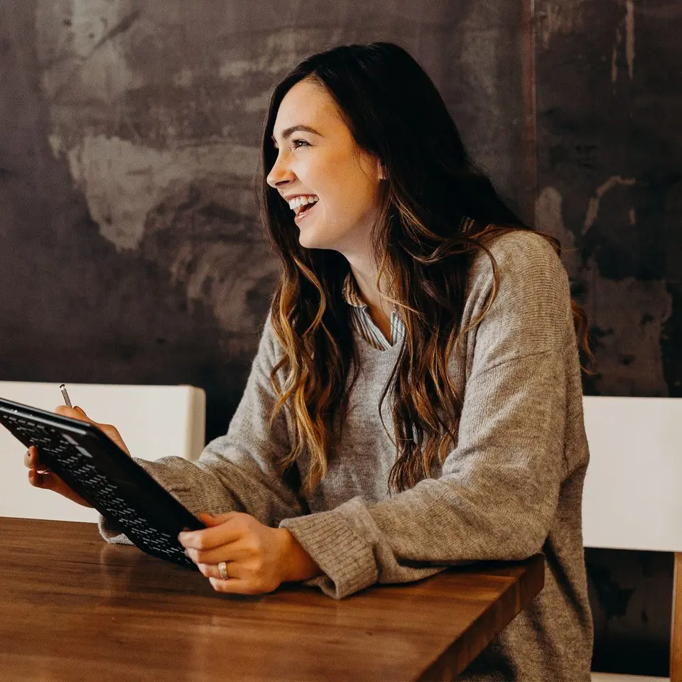 An HR specialist reading on a tablet in a busy office