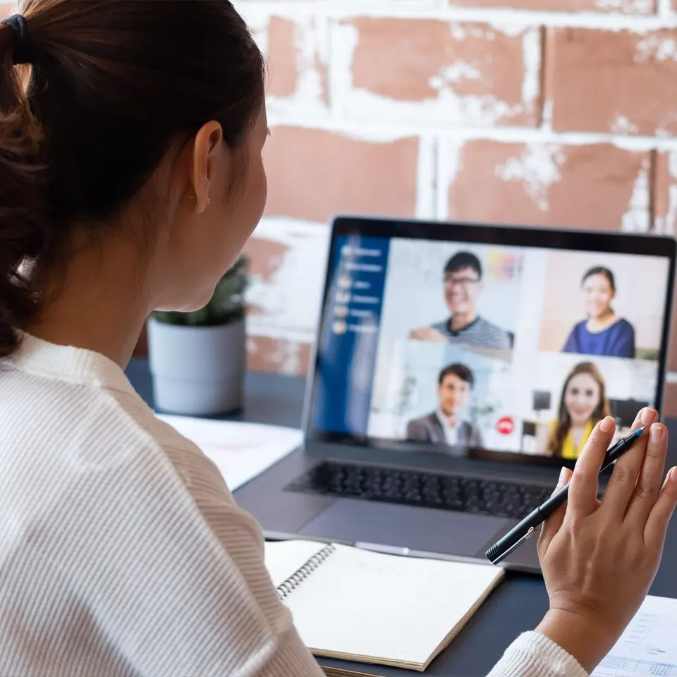 A consultant on a video call with four team members on screen
